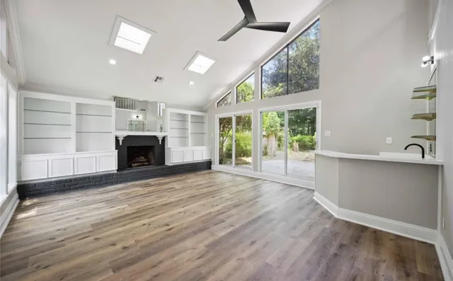a view of empty room with wooden floor and fireplace