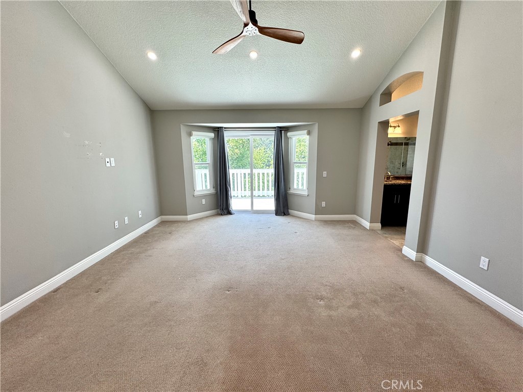 16073 Crestline Drive La Mirada, CA 90638 - Photo 20 of 75 an empty room with large windows and a ceiling fan