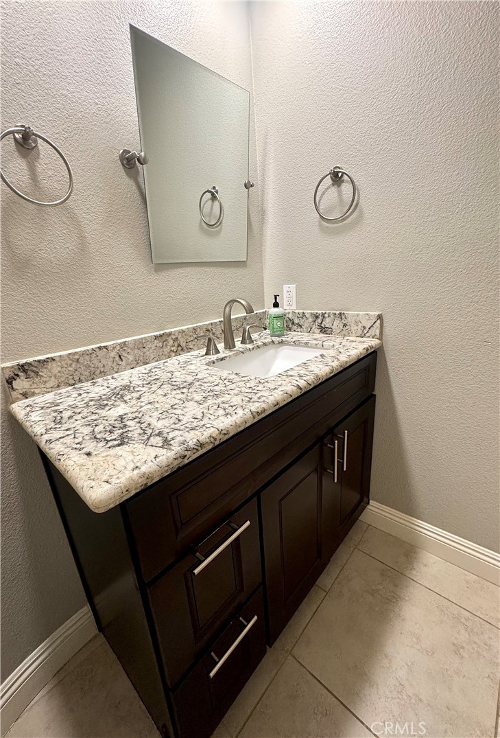 16073 Crestline Drive La Mirada, CA 90638 - Photo 30 of 75 a bathroom with a granite countertop sink and a mirror