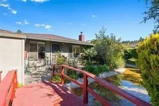 a view of a house with backyard and sitting area