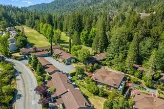 an aerial view of residential house with outdoor space and trees all around