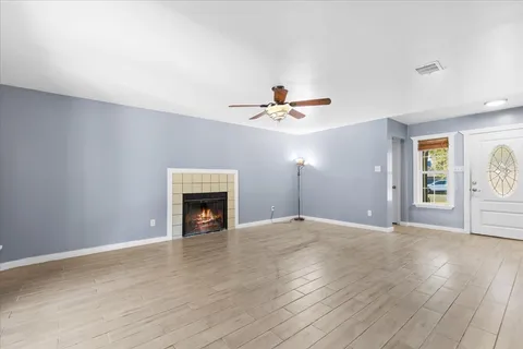 a view of an empty room with a fireplace and a window