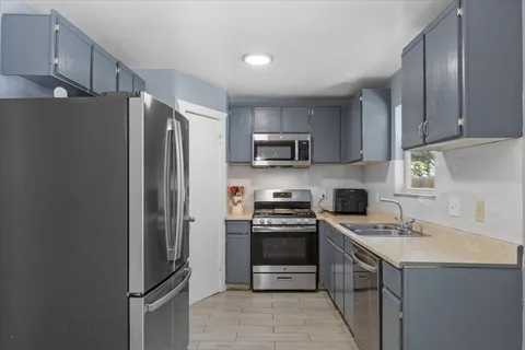 a kitchen with stainless steel appliances a refrigerator stove and sink