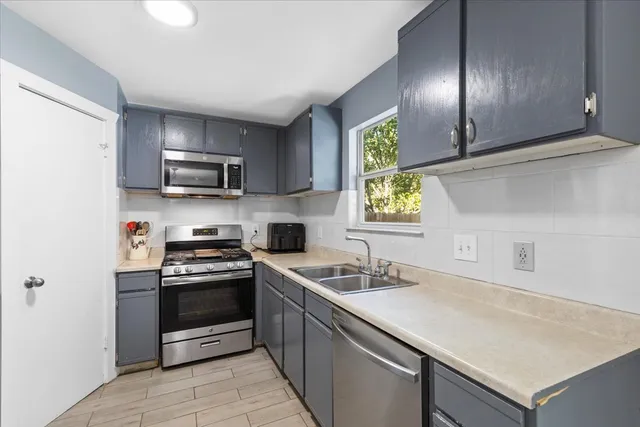 a kitchen with stainless steel appliances granite countertop a sink and a stove