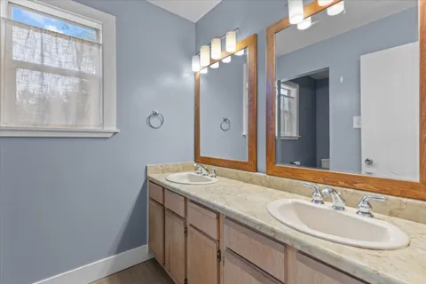 a bathroom with a granite countertop sink a large mirror and a vanity