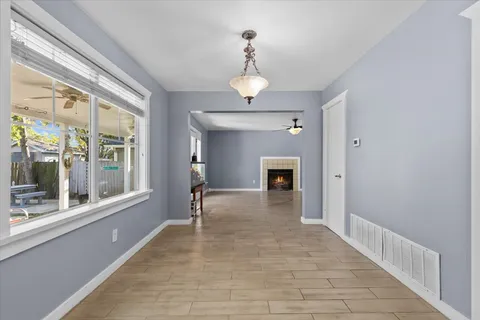 a view of an empty room with a fireplace and a window