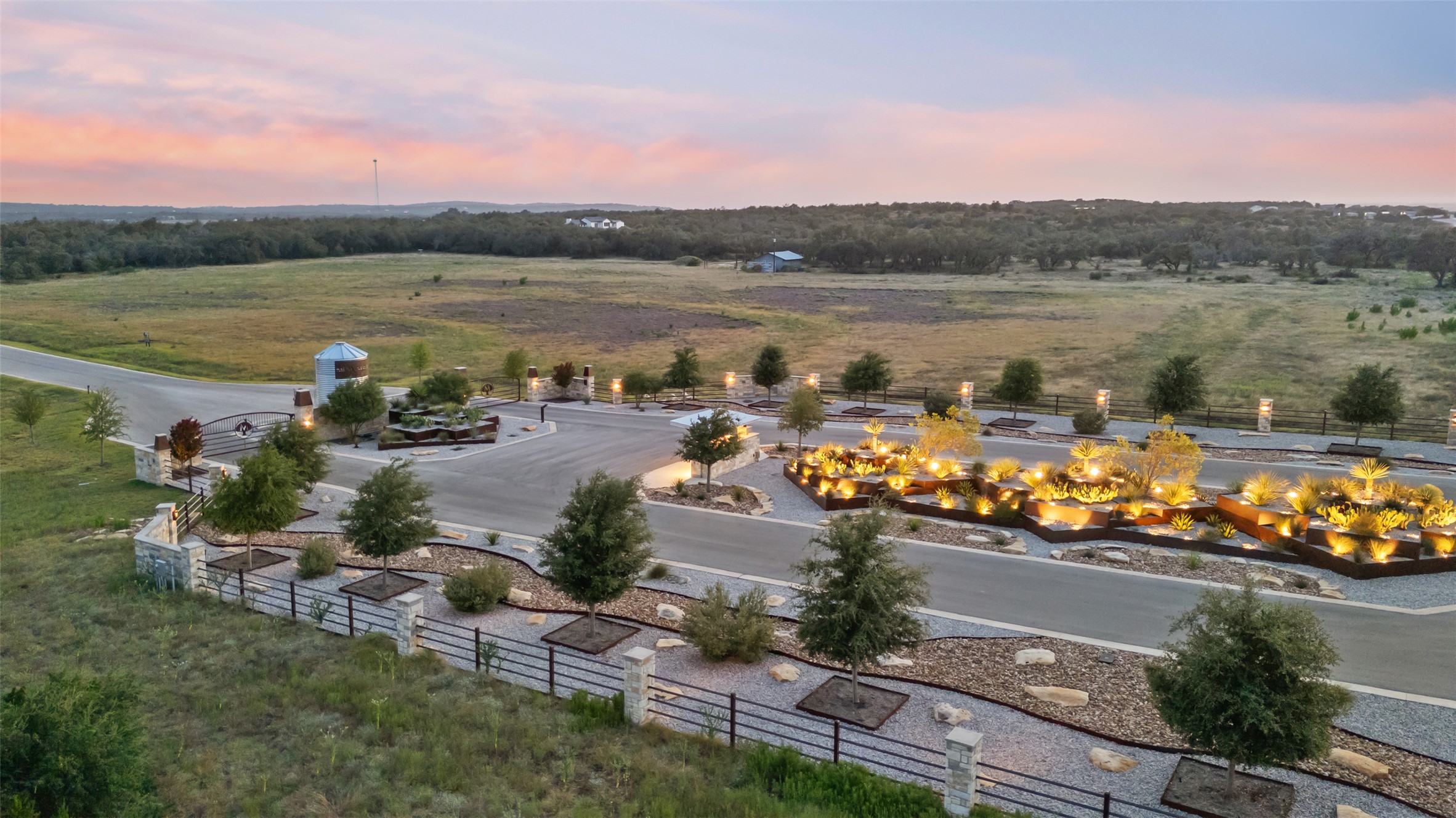 Lot 2 West Fitzhugh Road Dripping Springs, TX 78620 - Photo 4 of 9 An engineered entry drive winds past professional landscaping under expansive twilight skies.
