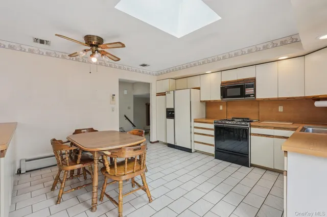 a kitchen with a table chairs refrigerator and cabinets