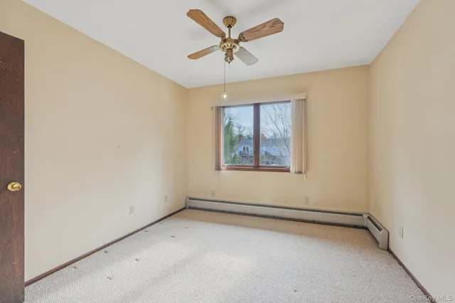 a view of a big room with windows and chandelier fan