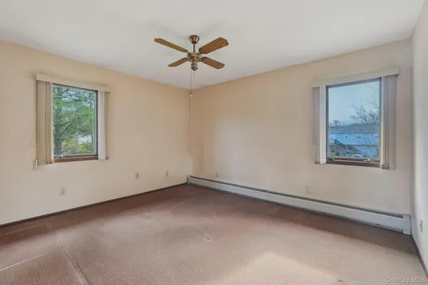 an empty room with fan and windows