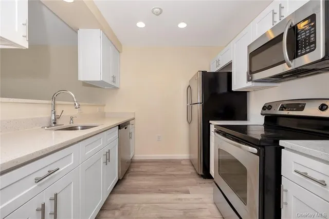 a kitchen with stainless steel appliances a stove microwave and sink