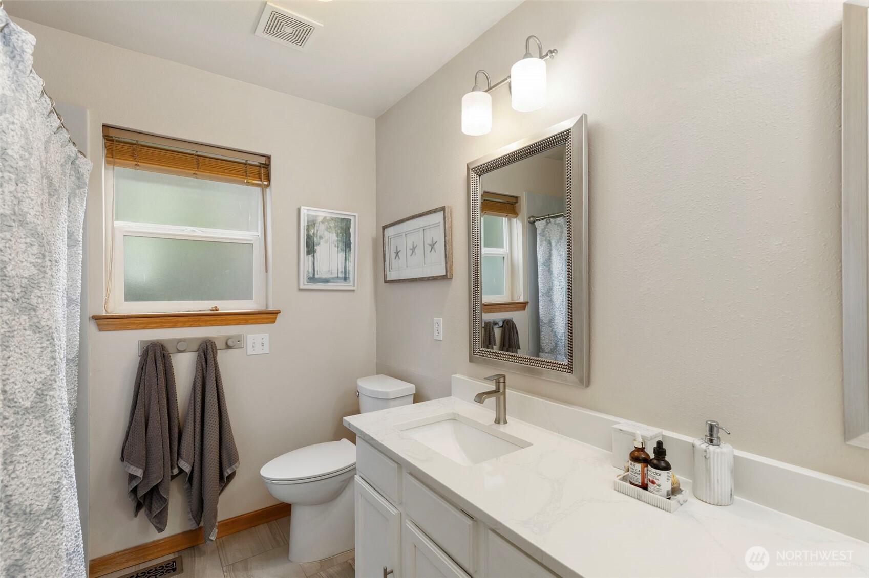 9240 Priddy Vista Road Northwest Seabeck, WA 98380 - Photo 18 of 40 a bathroom with a sink a toilet and mirror