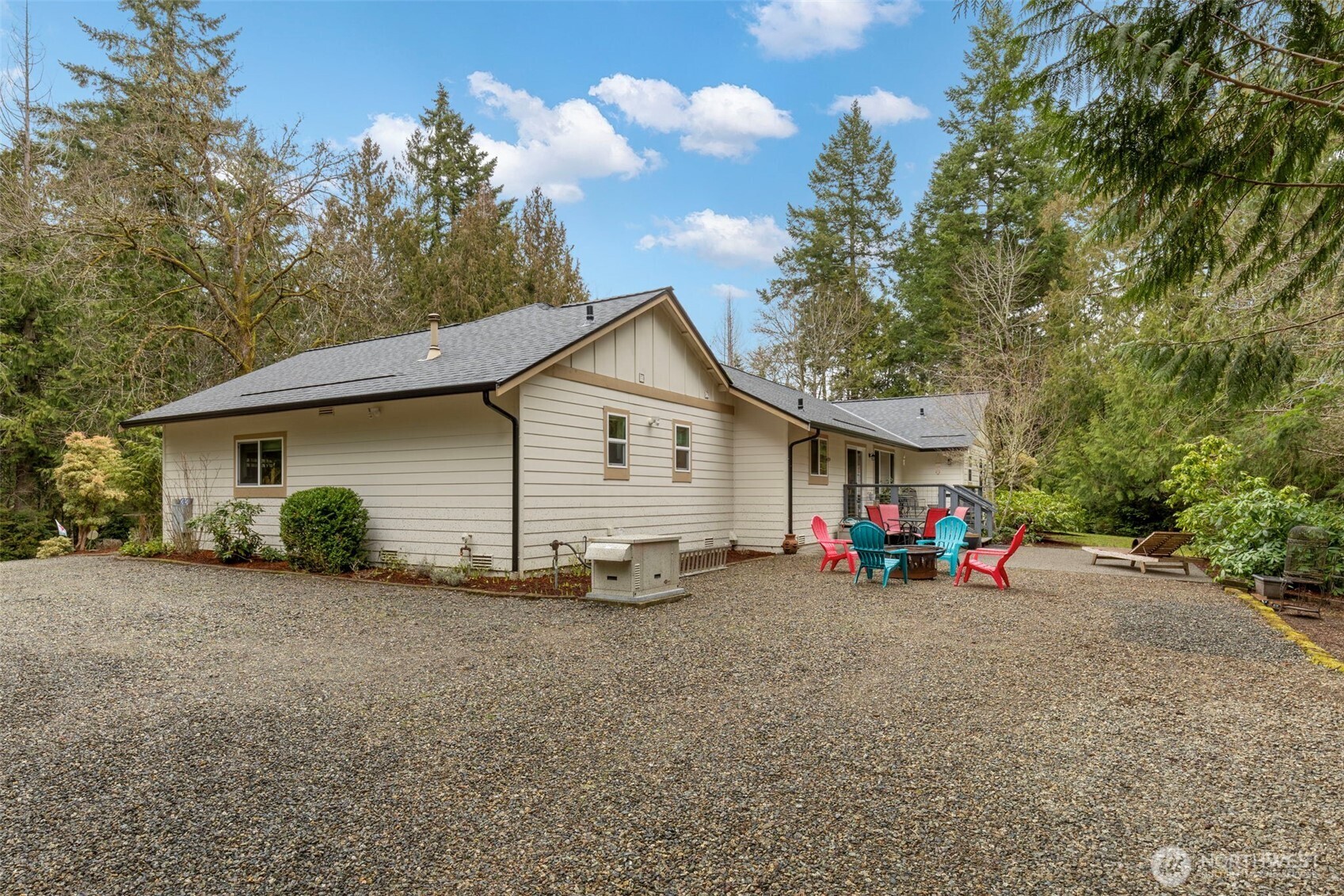 9240 Priddy Vista Road Northwest Seabeck, WA 98380 - Photo 30 of 40 a view of a house with a yard and lawn chairs
