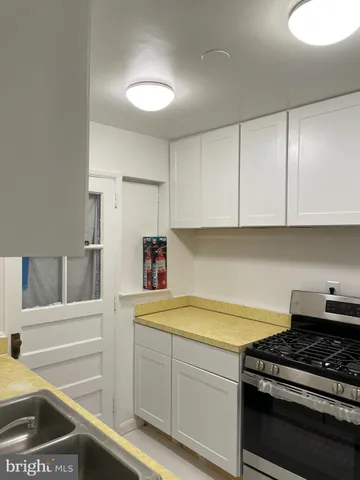 a kitchen with a sink stove and cabinets