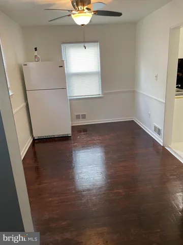 an empty room with wooden floor and cabinet