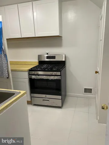 a stove top oven sitting inside of a kitchen