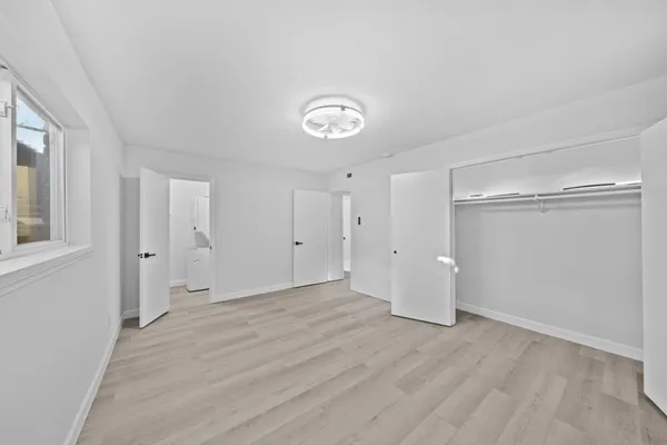 a view of a room with wooden floor and white walls