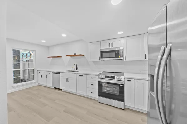 a kitchen with stainless steel appliances granite countertop a stove a sink and a refrigerator