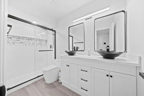 a bathroom with a double vanity sink toilet and mirror