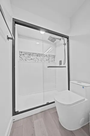 a bathroom with a glass shower door and a window