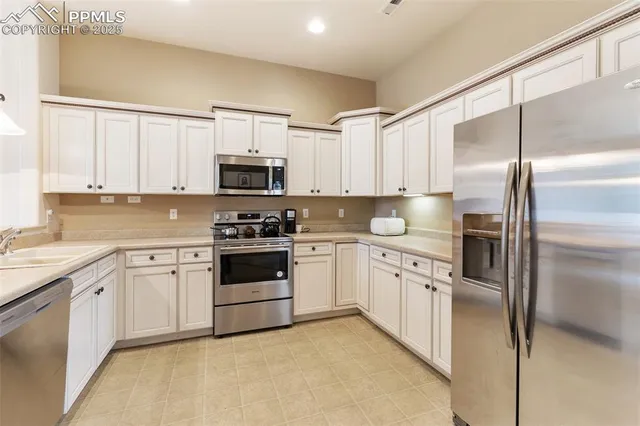 a kitchen with cabinets stainless steel appliances and a window
