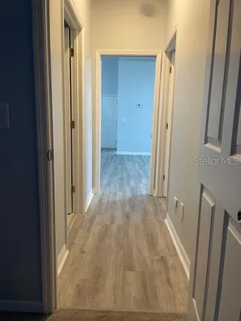 a view of a hallway to rooms