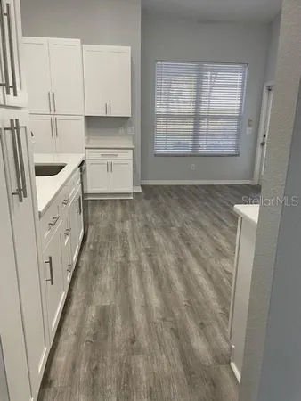 a kitchen with granite countertop white cabinets and sink