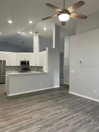 a view of kitchen with granite countertop cabinets and stainless steel appliances