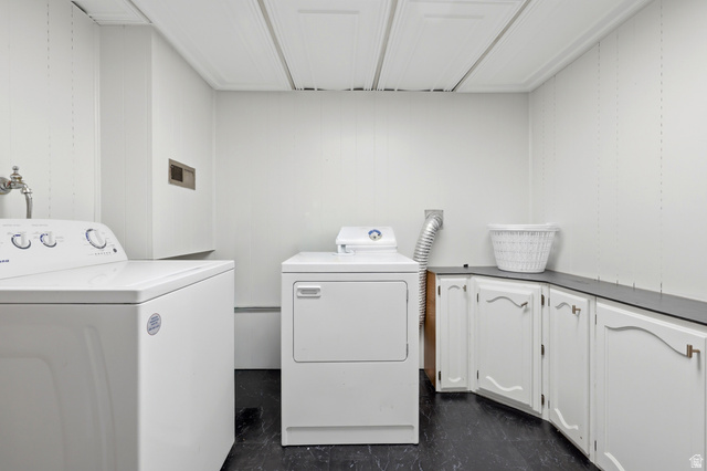 1486 3rd Street Ogden, UT 84404 - Photo 16 of 26 Dedicated laundry area featuring a washer and dryer, white paneling, built-in white cabinetry, a dark countertop, and dark flooring