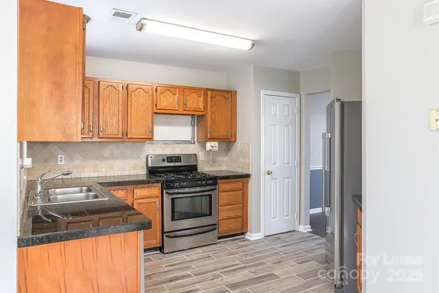 a kitchen with a stove sink and cabinets