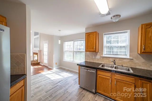 a kitchen with stainless steel appliances granite countertop wooden floors and sink