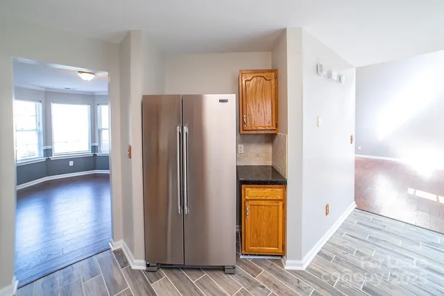 a view of a hallway with wooden floor and a bathroom