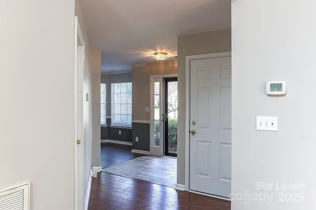 a view of hallway with livingroom and wooden floor