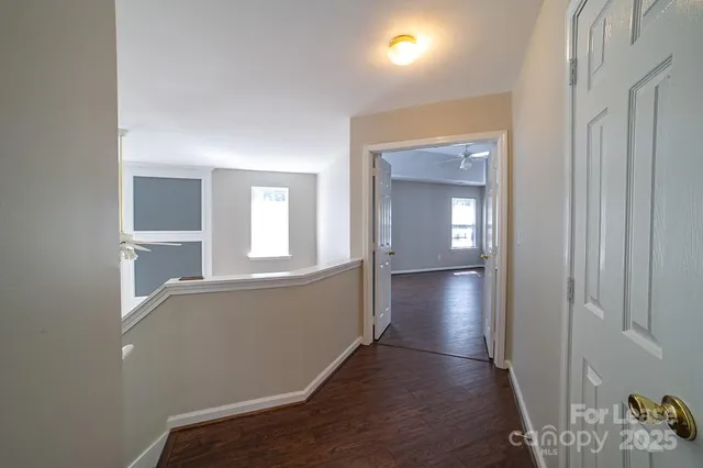 a view of an empty room with closet and a window