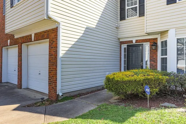 a house with a yard and potted plants