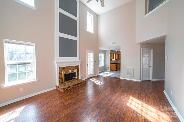 wooden floor fireplace and windows in an empty room