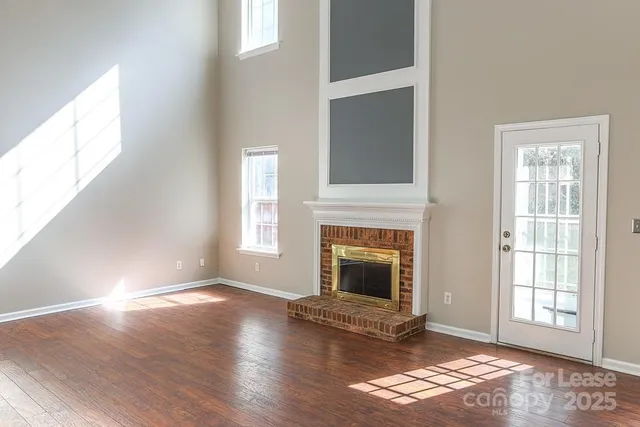 a view of empty room with wooden floor and fireplace