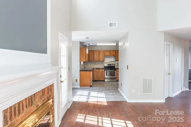 a view of kitchen with stainless steel appliances wooden floor and large window