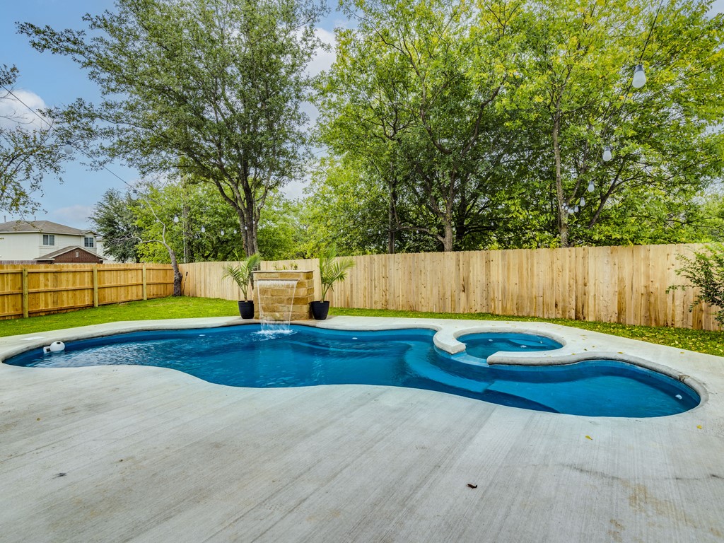 1415 Roxanne's Run Pflugerville, TX 78660 - Photo 28 of 30 A tranquil backyard oasis features a freeform pool with a built-in spa and a decorative waterfall feature.