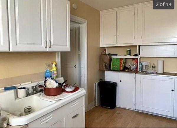 a kitchen with white cabinets and sink