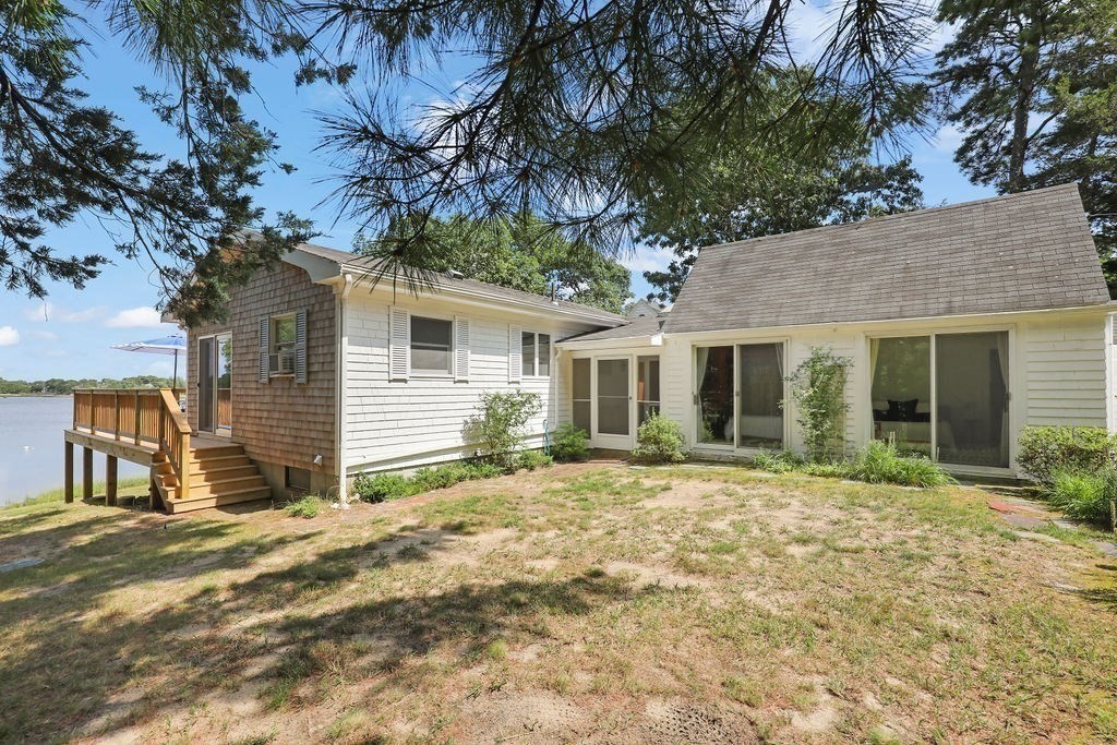 14 Salt Marsh Lane Wareham, MA 02571 - Photo 36 of 42 a backyard of a house with large trees and outdoor seating