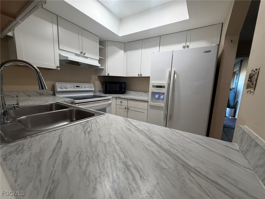 817 Gleason Parkway, Unit 3 Cape Coral, FL 33914 - Photo 2 of 12 a kitchen with stainless steel appliances a refrigerator a sink a stove and white cabinets