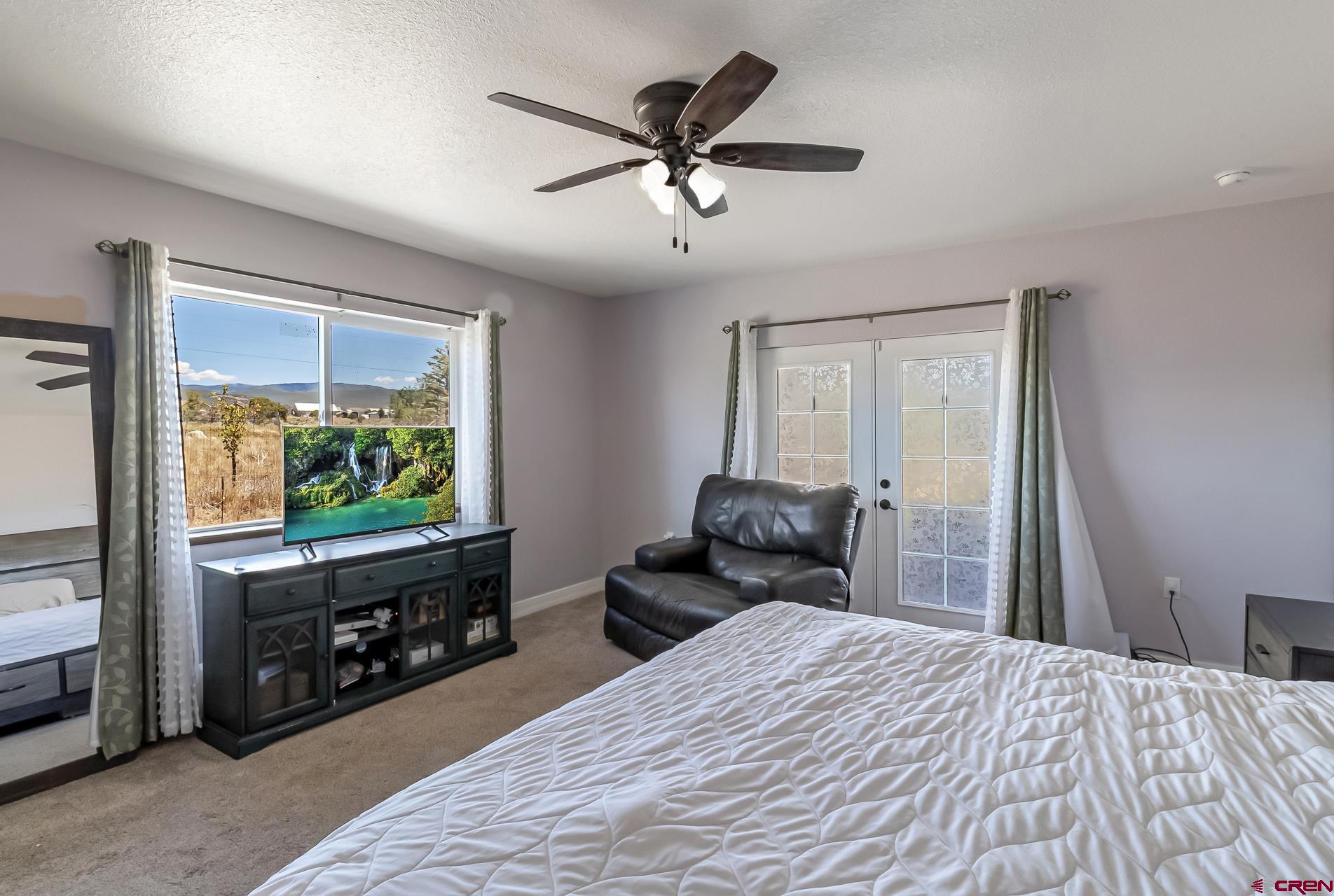 15969 Stardust Lane Cedaredge, CO 81413 - Photo 19 of 44 a bedroom with a bed and a flat screen tv