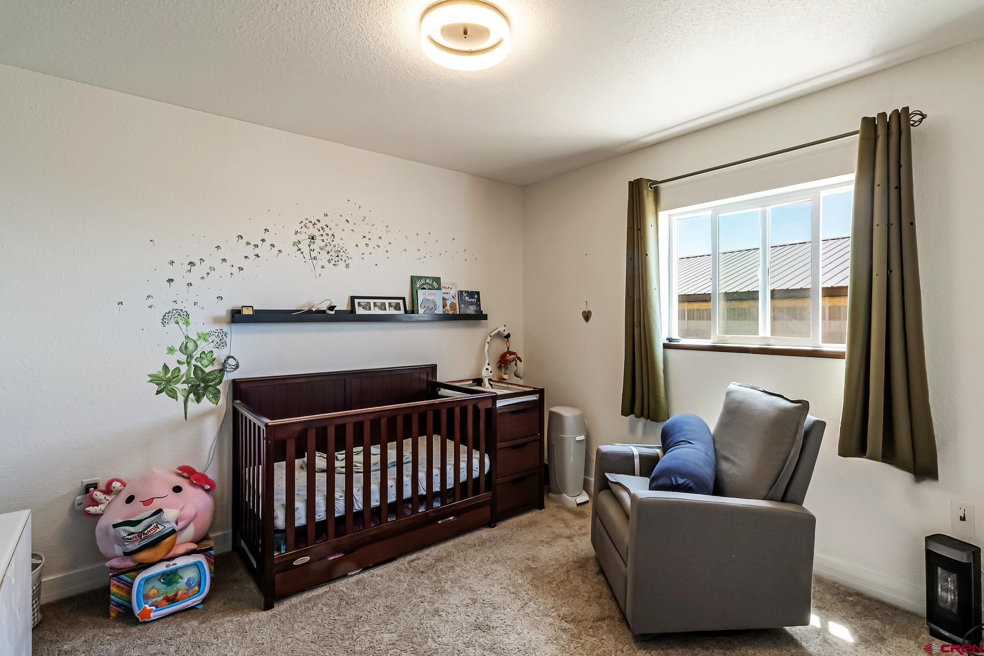 15969 Stardust Lane Cedaredge, CO 81413 - Photo 23 of 44 a bedroom with furniture and a window