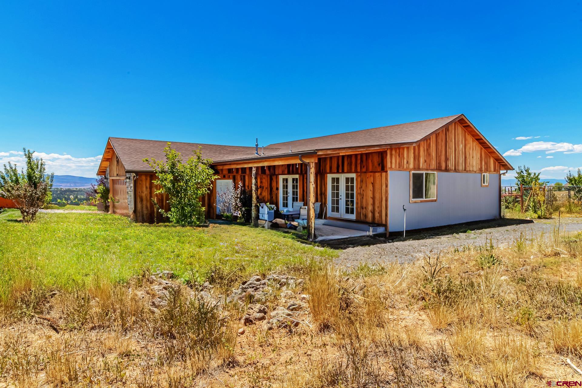 15969 Stardust Lane Cedaredge, CO 81413 - Photo 39 of 44 a backyard of a house with wooden fence and a bench