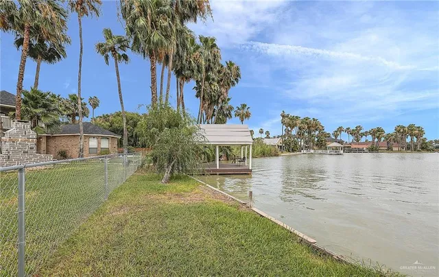 a view of a lake with a big yard and palm trees