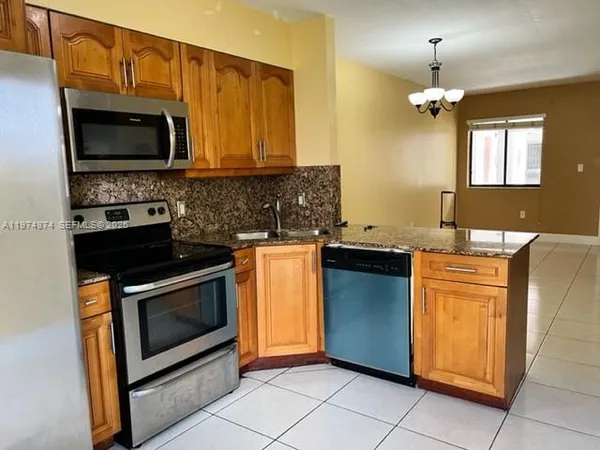 a kitchen with stainless steel appliances granite countertop a stove microwave and sink
