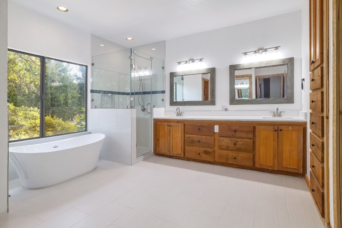 313 Kendall Road Spicewood, TX 78669 - Photo 13 of 34 a bathroom with a granite countertop sink mirror bathtub and toilet