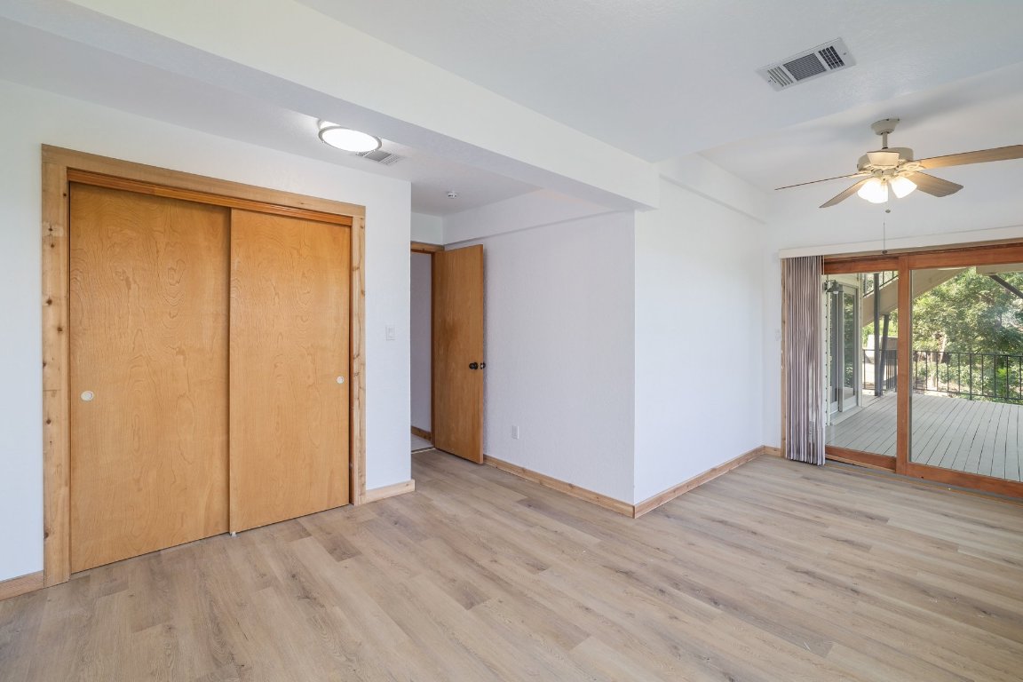 313 Kendall Road Spicewood, TX 78669 - Photo 21 of 34 an empty room with wooden floor and windows