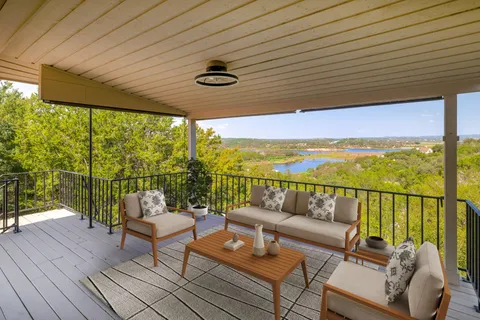 a balcony with wooden floor and outdoor seating